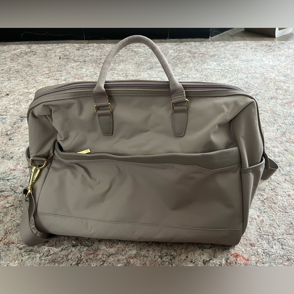 Taupe water resistant weekender bag with many compartments and ways to carry